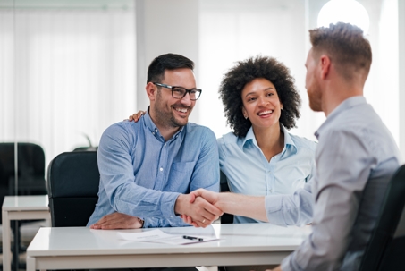 couple shaking hands with a lawyer