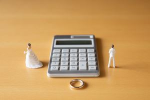 wedding figurines next to a calculator