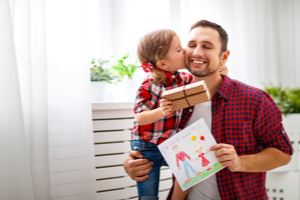 dad with his daughter holding a painting